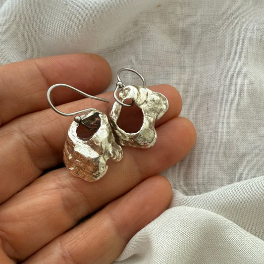 Broken oyster shell earrings worn on model