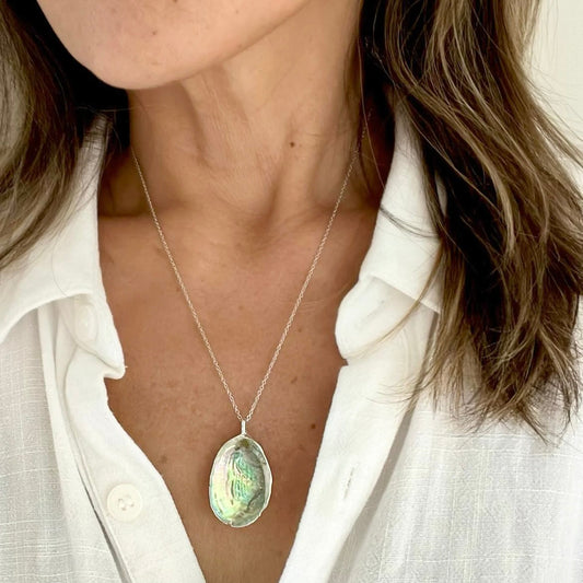 Paua shell silver pendant necklace worn close-up