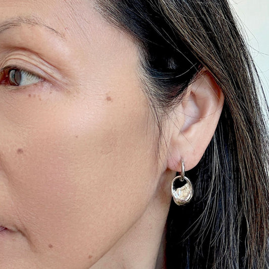Pupu sea snail shell hoop earrings worn on model