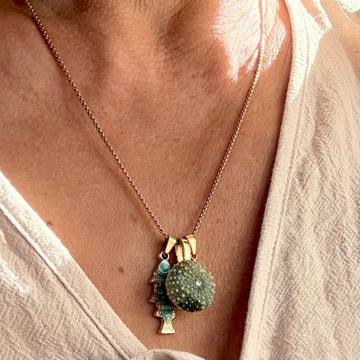 Kina and fish charm necklace close-up detail