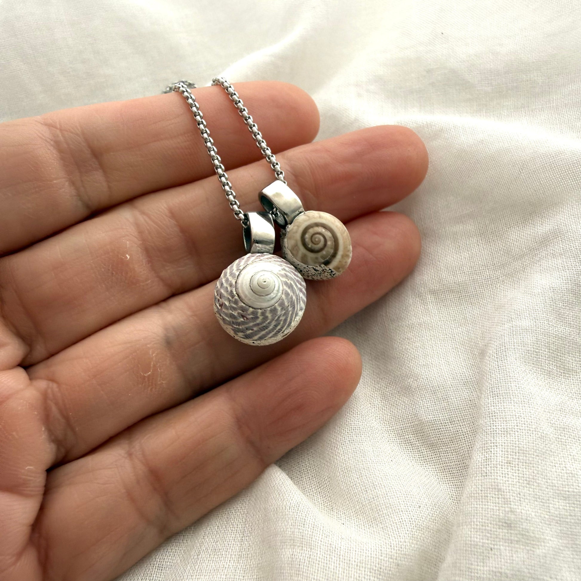 Koru spiral shell necklace worn on model