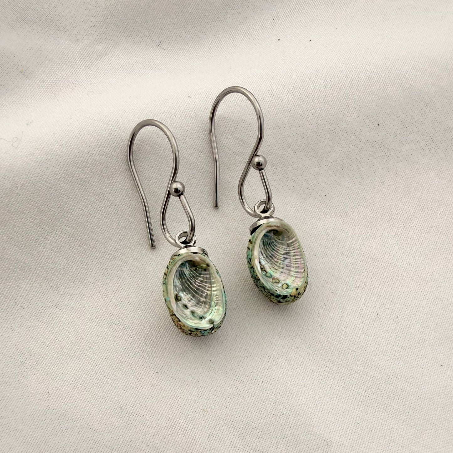 Paua shell dangle hook earrings worn, handmade New Zealand jewellery