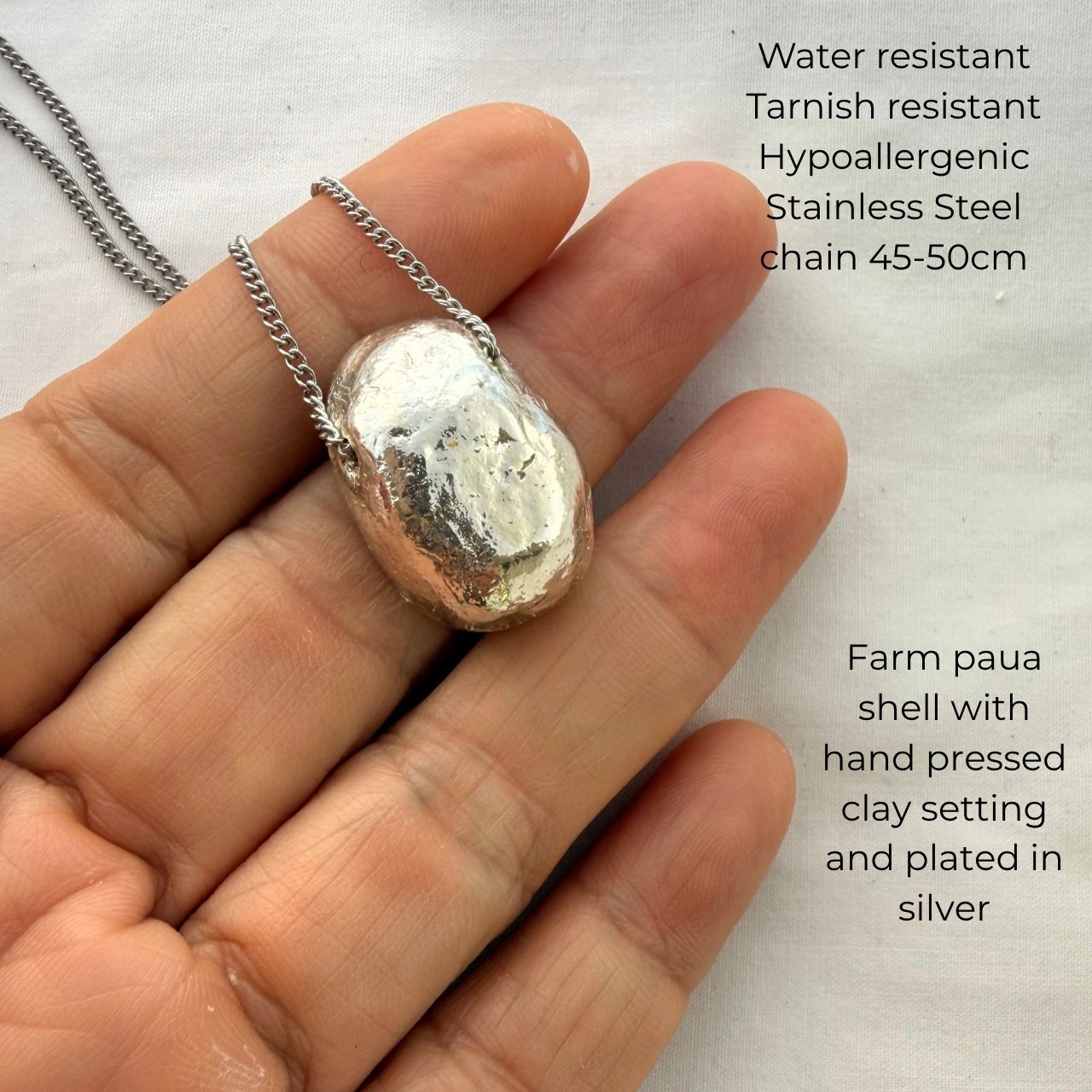 Paua shell pendant beachsand clay setting detail