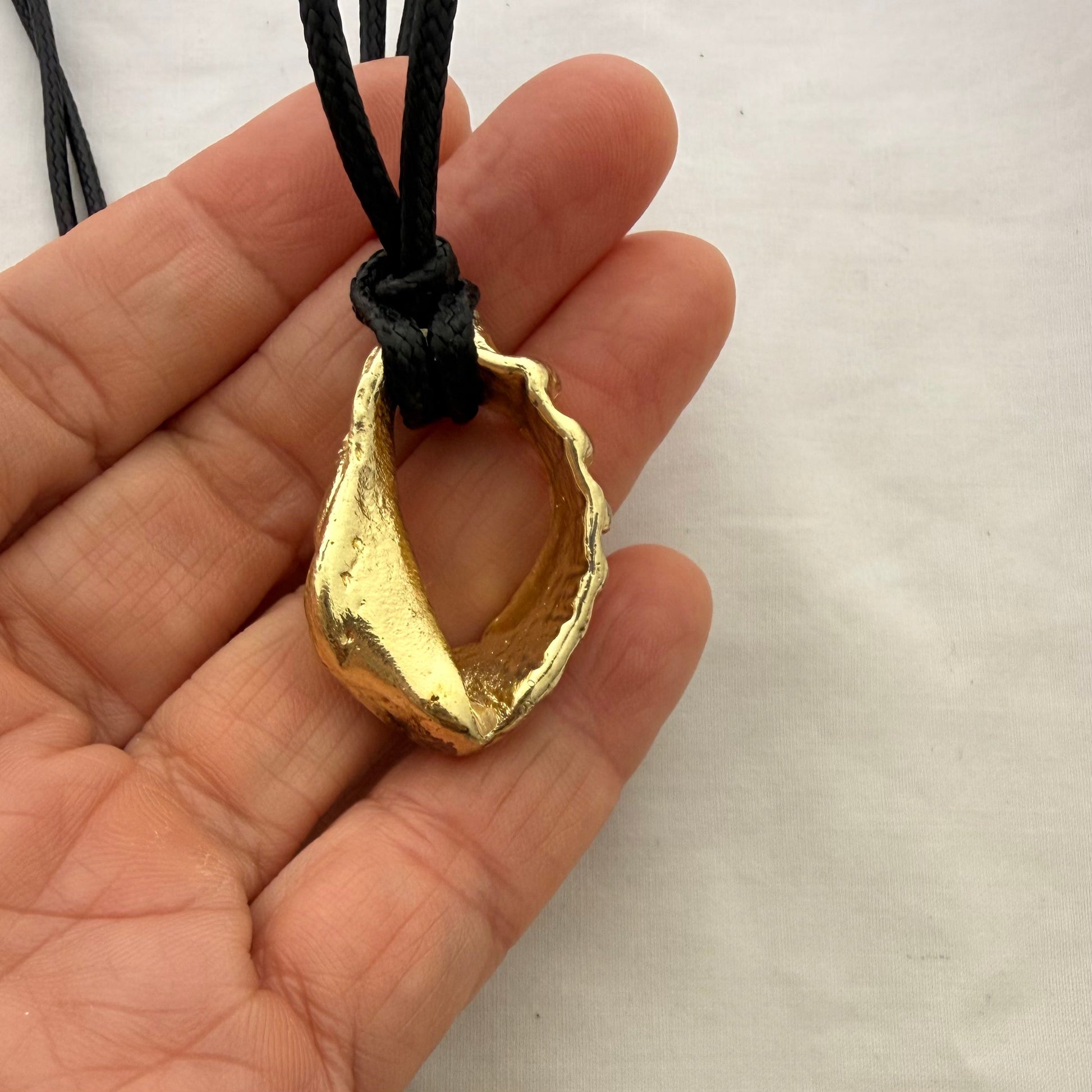 Gold whelk shell cord necklace close-up detail