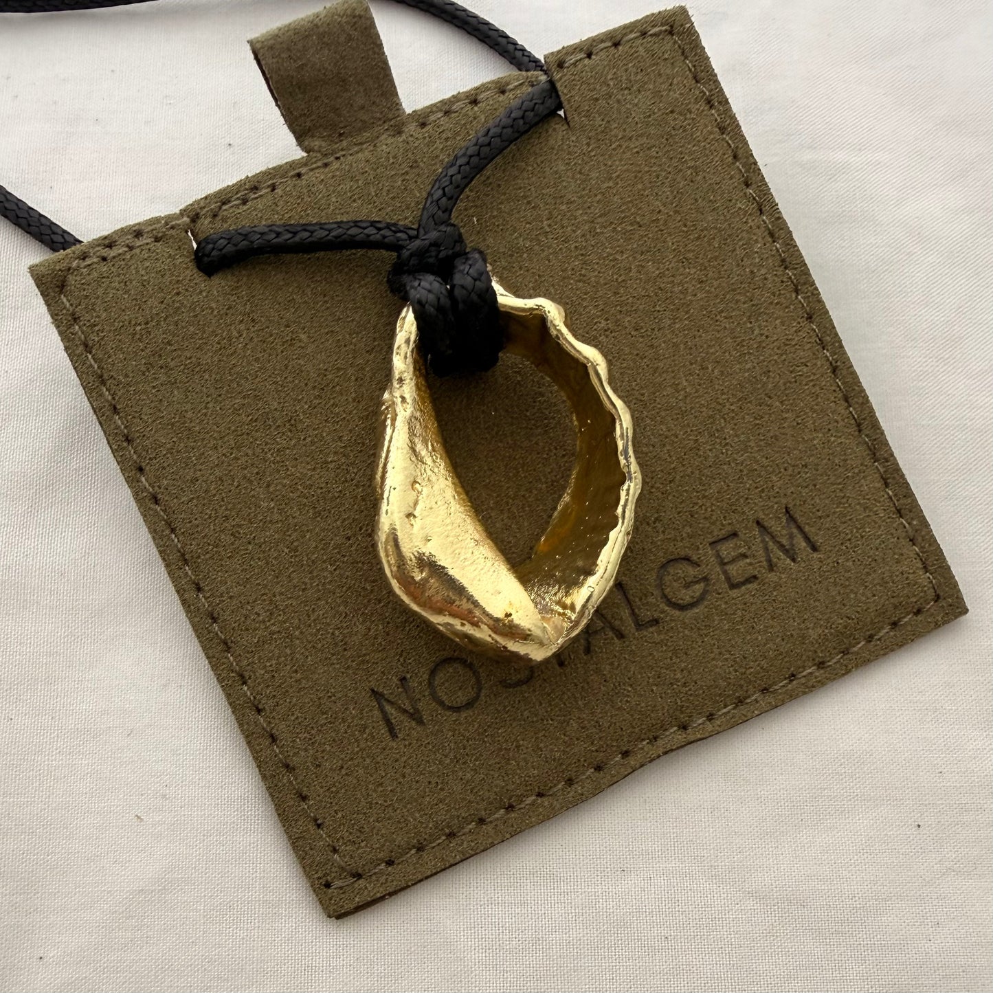 Gold whelk shell cord necklace styled shot
